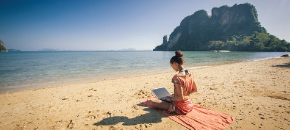 אישה יושבת בים עם מחשב